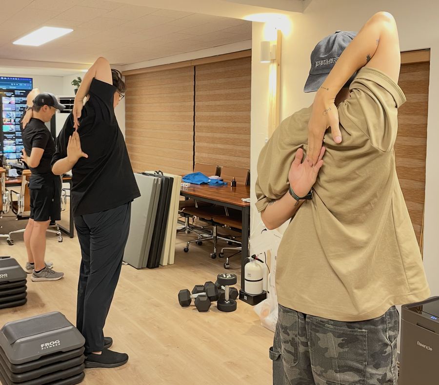 사무실에서 전문가와 함께 스트레칭하는 임직원들